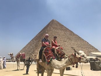 Wolfgang und Christiane auf Kamelen vor einer der Pyramiden von Gizeh
