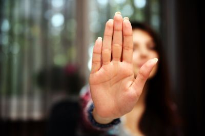 Eine Frau, die die Hand hebt um 'Stop' zu signalisieren